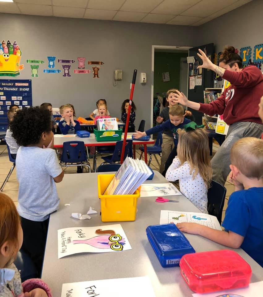 Adult interacting with children in a classroom