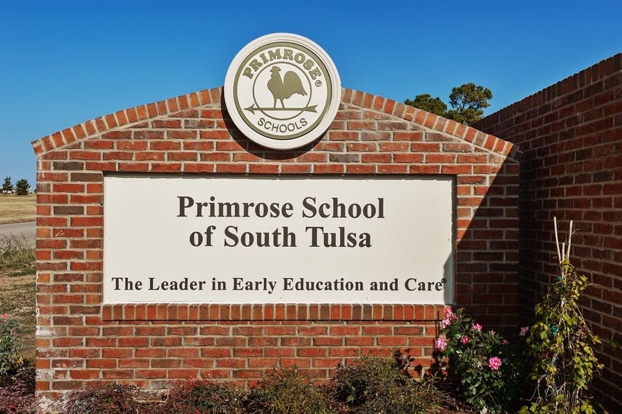 Primrose School of South Tulsa sign on a brick wall