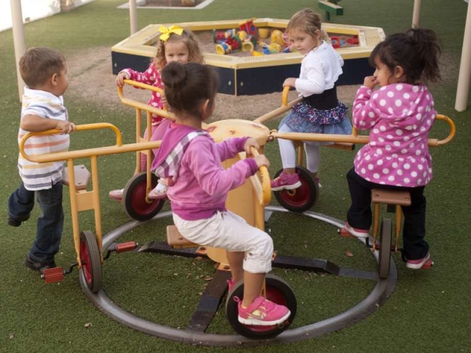 Children playing on a playground merry-go-round