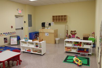 Empty classroom with shelves of toys and small tables