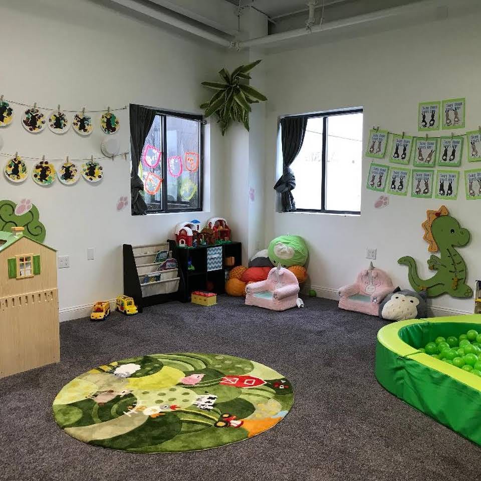 Playroom with a ball pit, small chairs, and a round rug