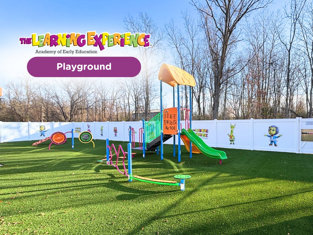 Colorful playground with various equipment and a white fence