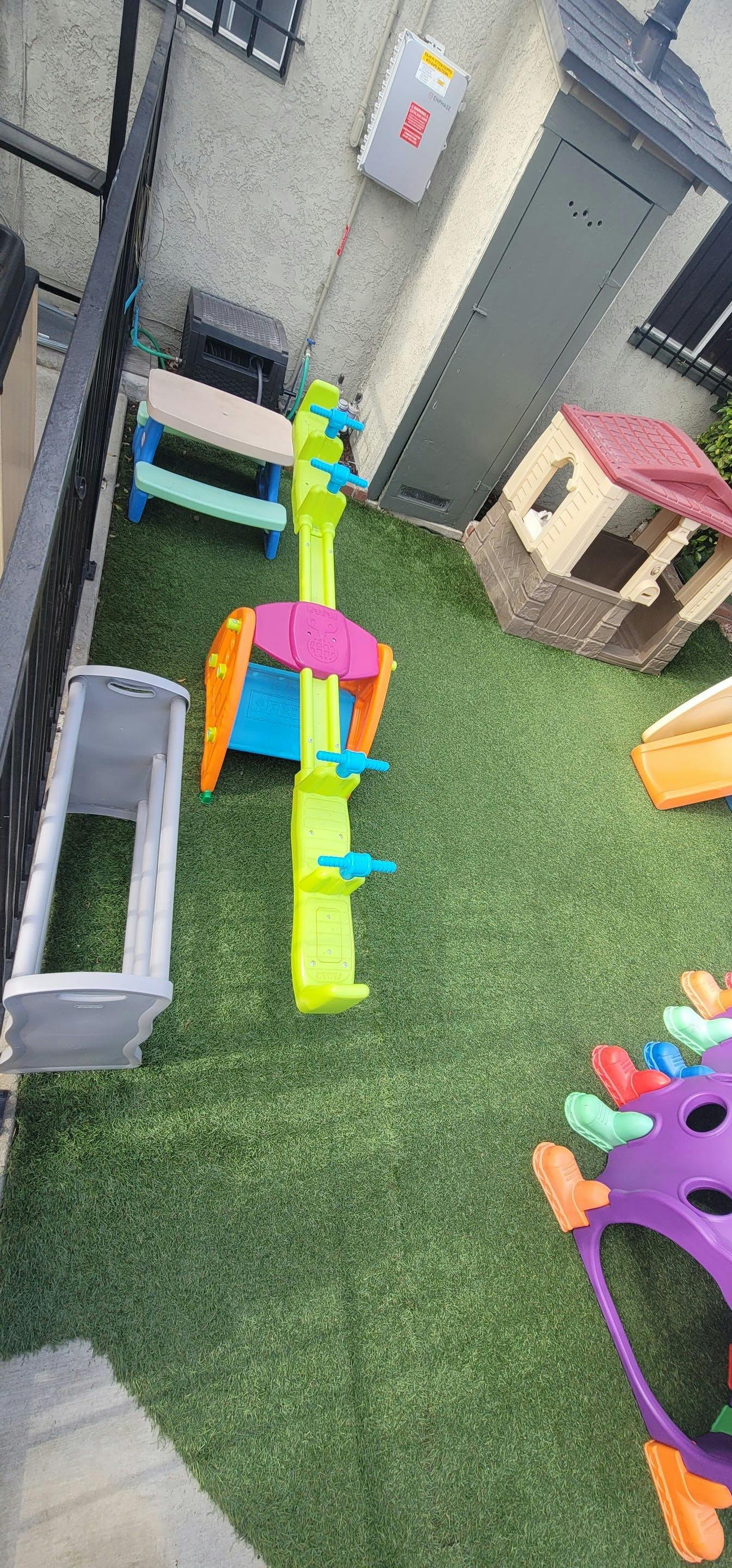 Playground with colorful plastic play structures on artificial turf
