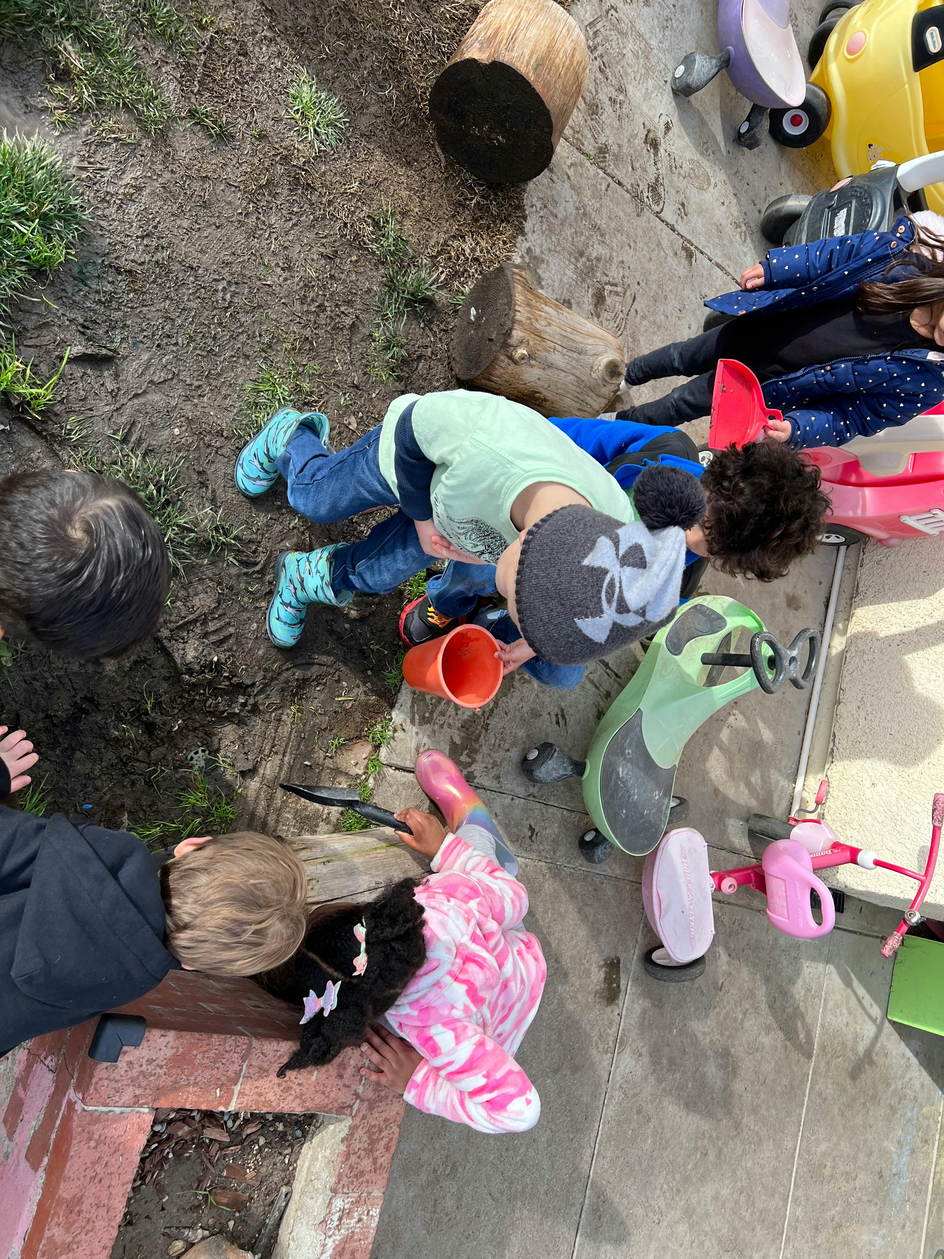 Children playing in dirt with toys