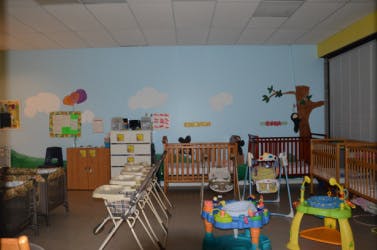 Nursery room with cribs, high chairs, and infant play equipment