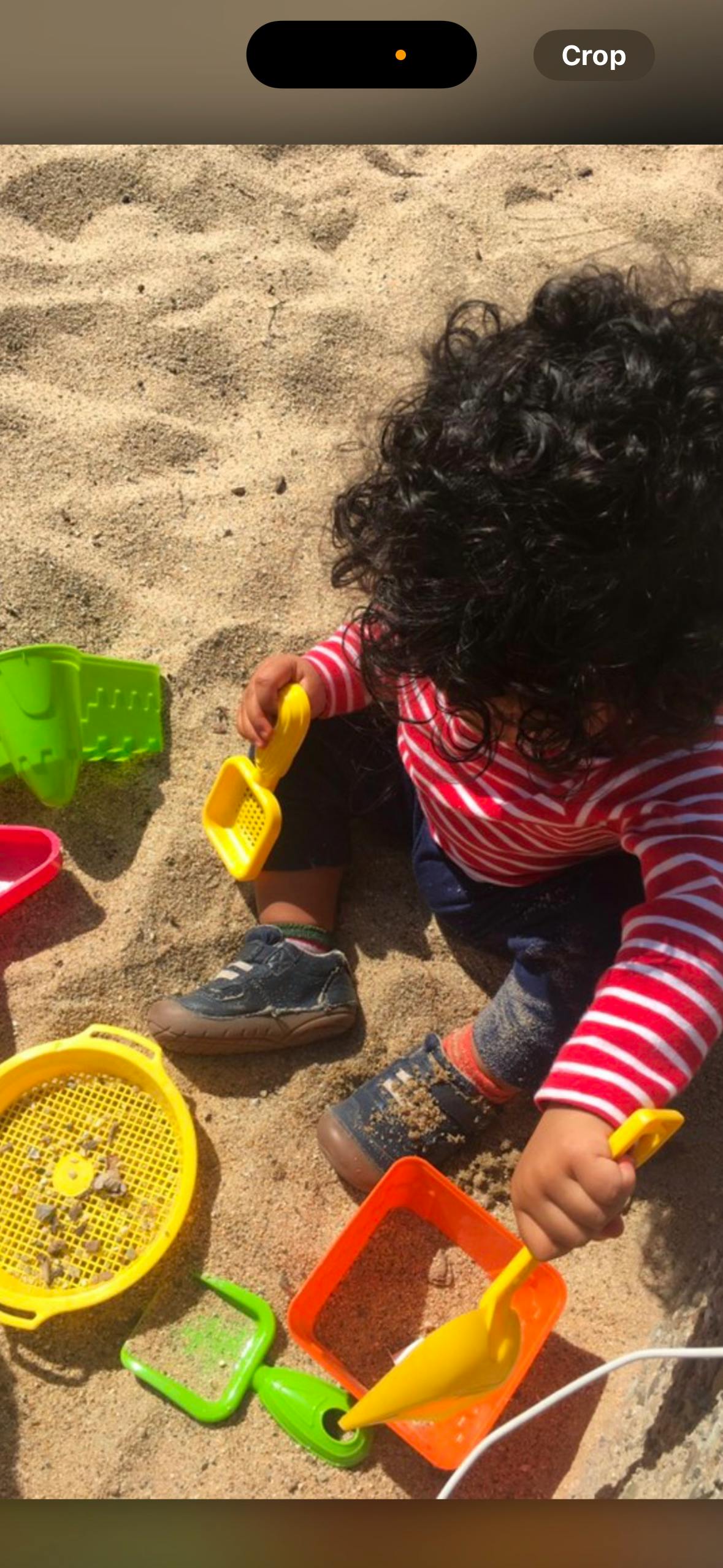 Child playing in sand with sand toys