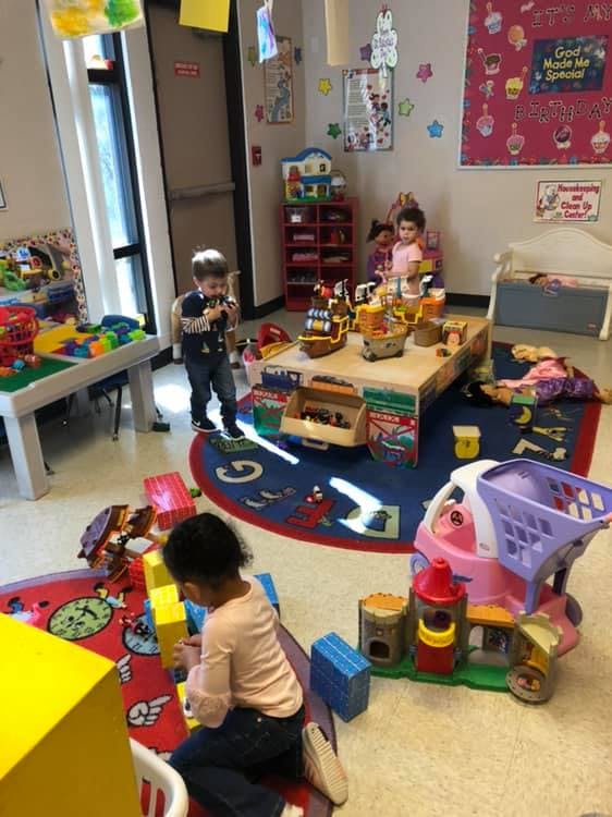 Three children playing with toys in a classroom