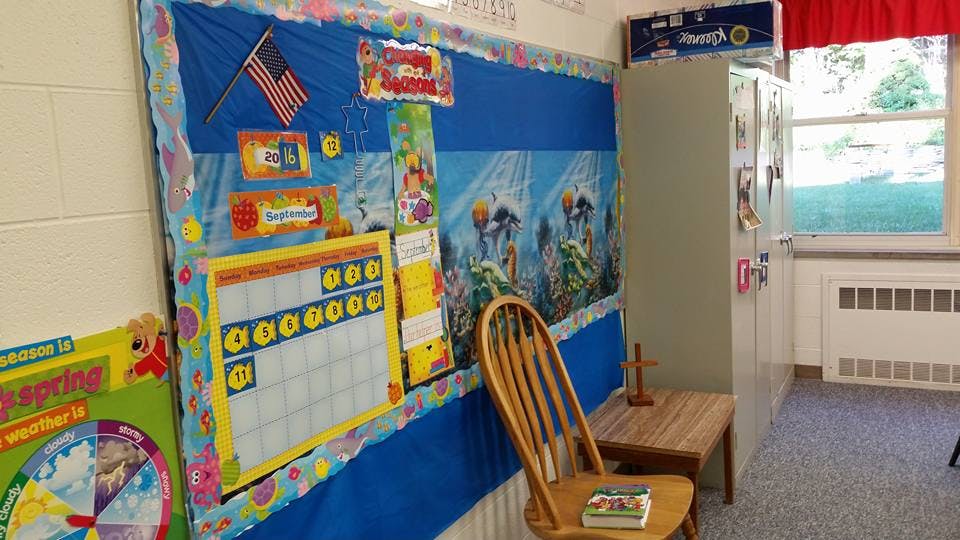 Classroom bulletin board with calendar and American flag