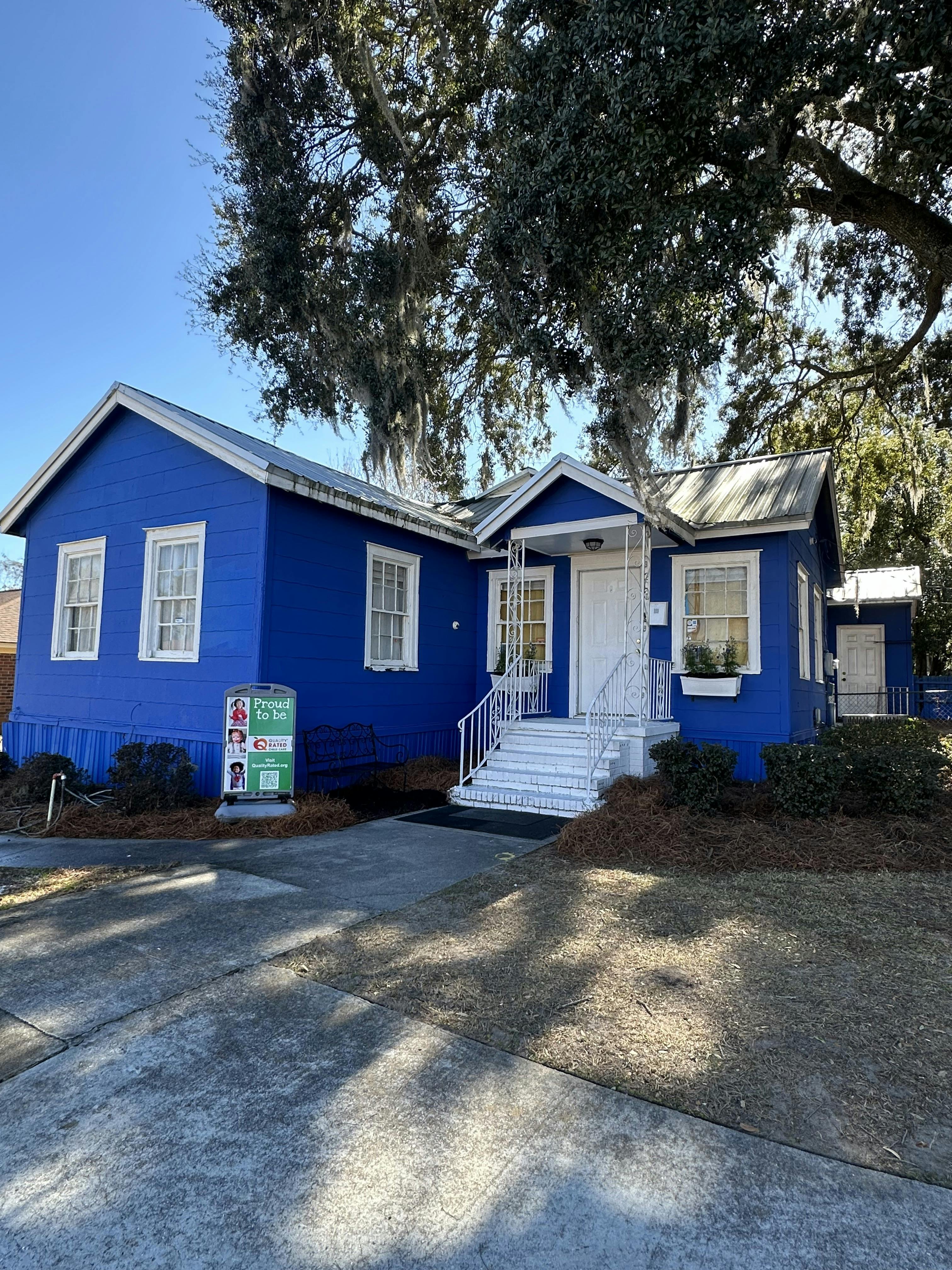 Bright blue building with white trim and Proud to be sign
