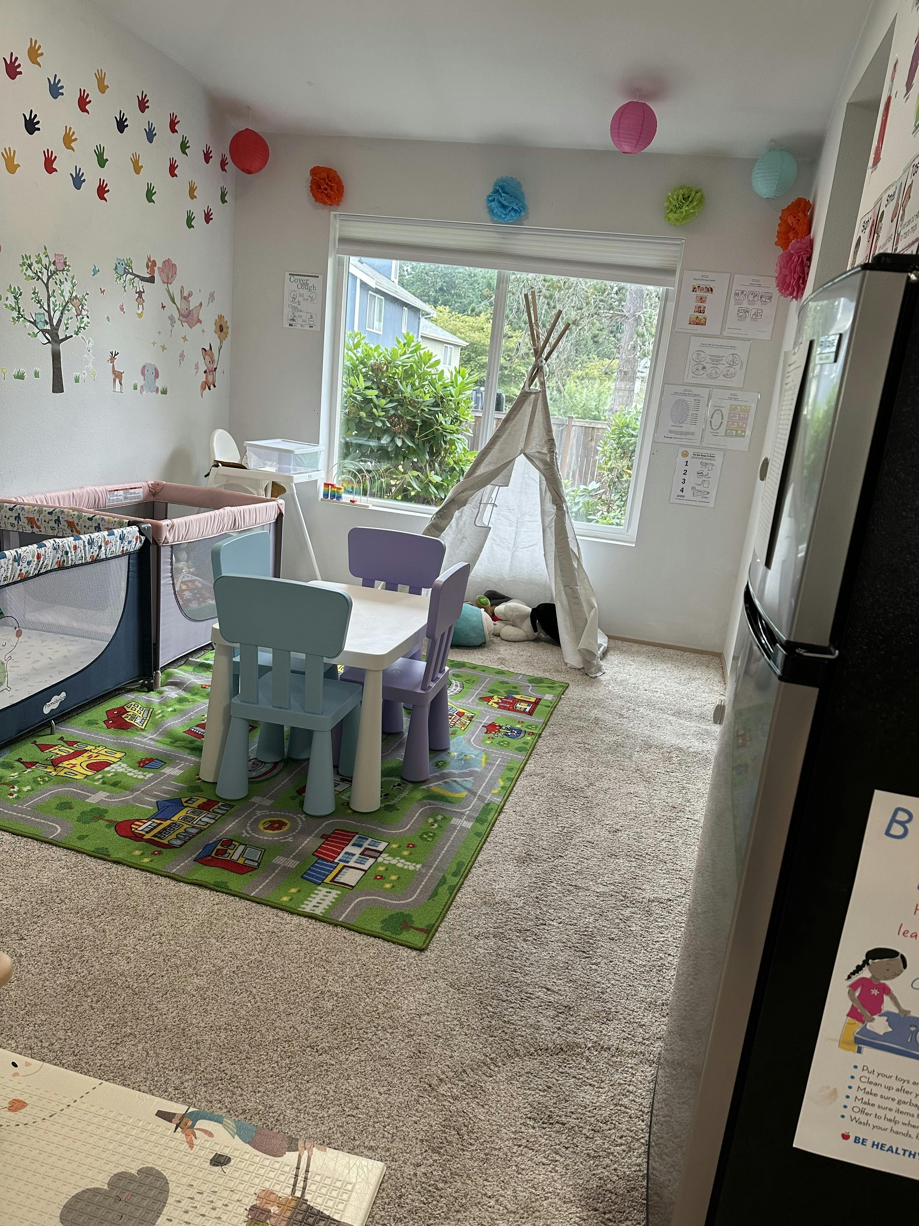 Playroom with a play tent, children's table, chairs, and playpen