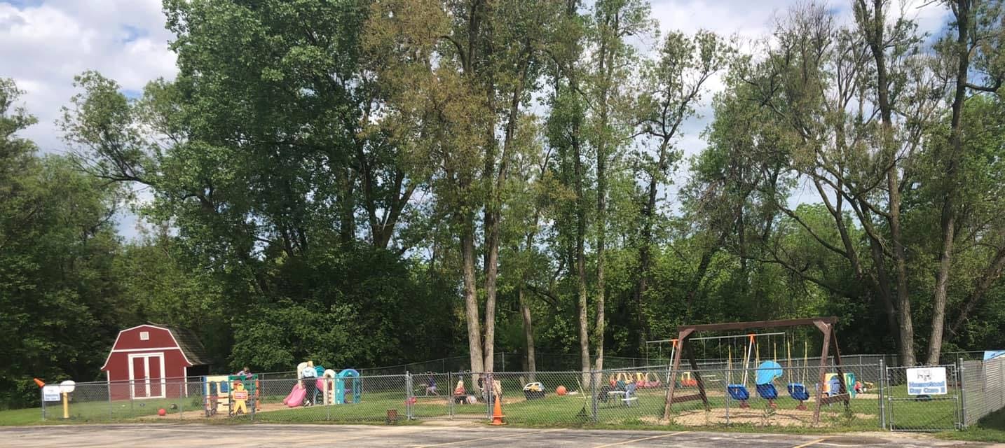 Playground with swings, slides, and a red barn