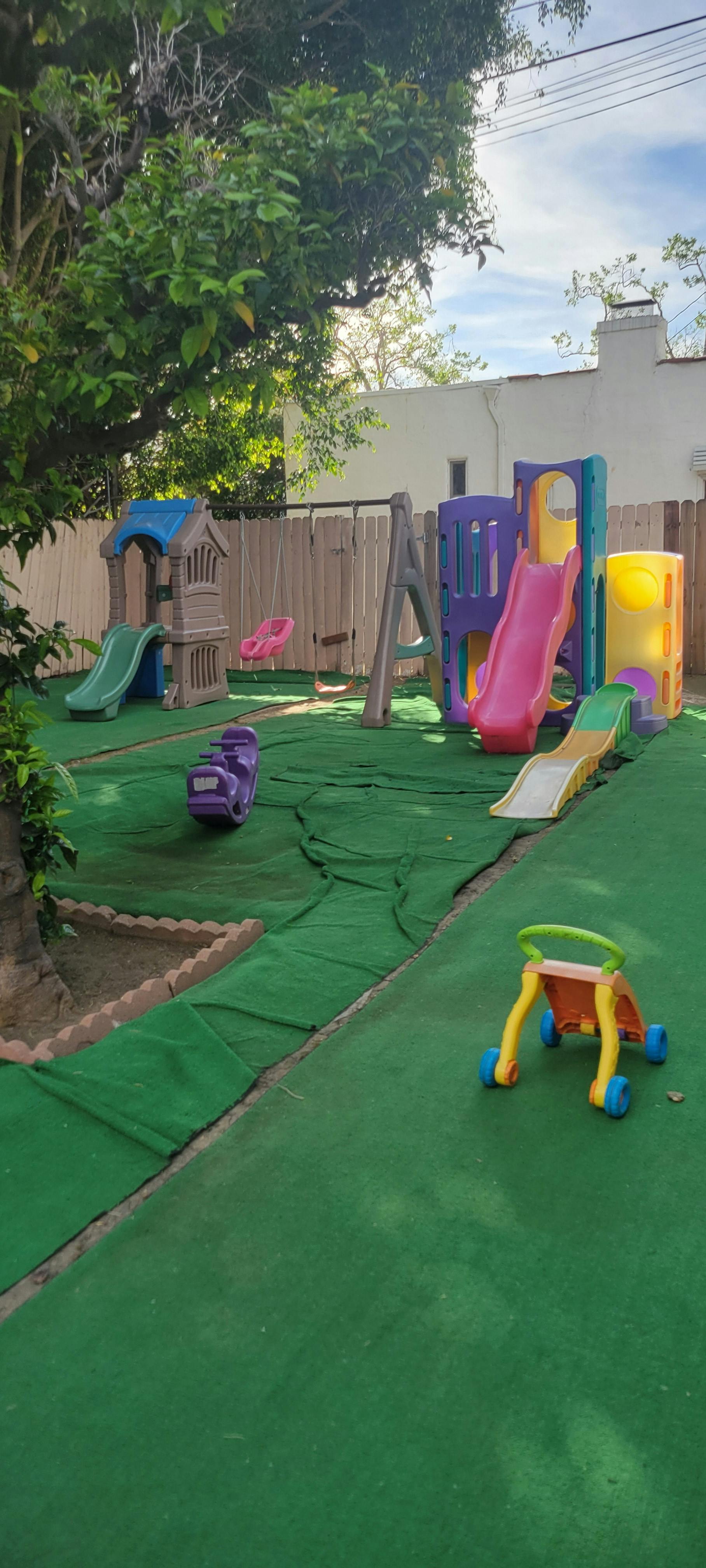 Children's playground with slides, swings, and play structures on green turf