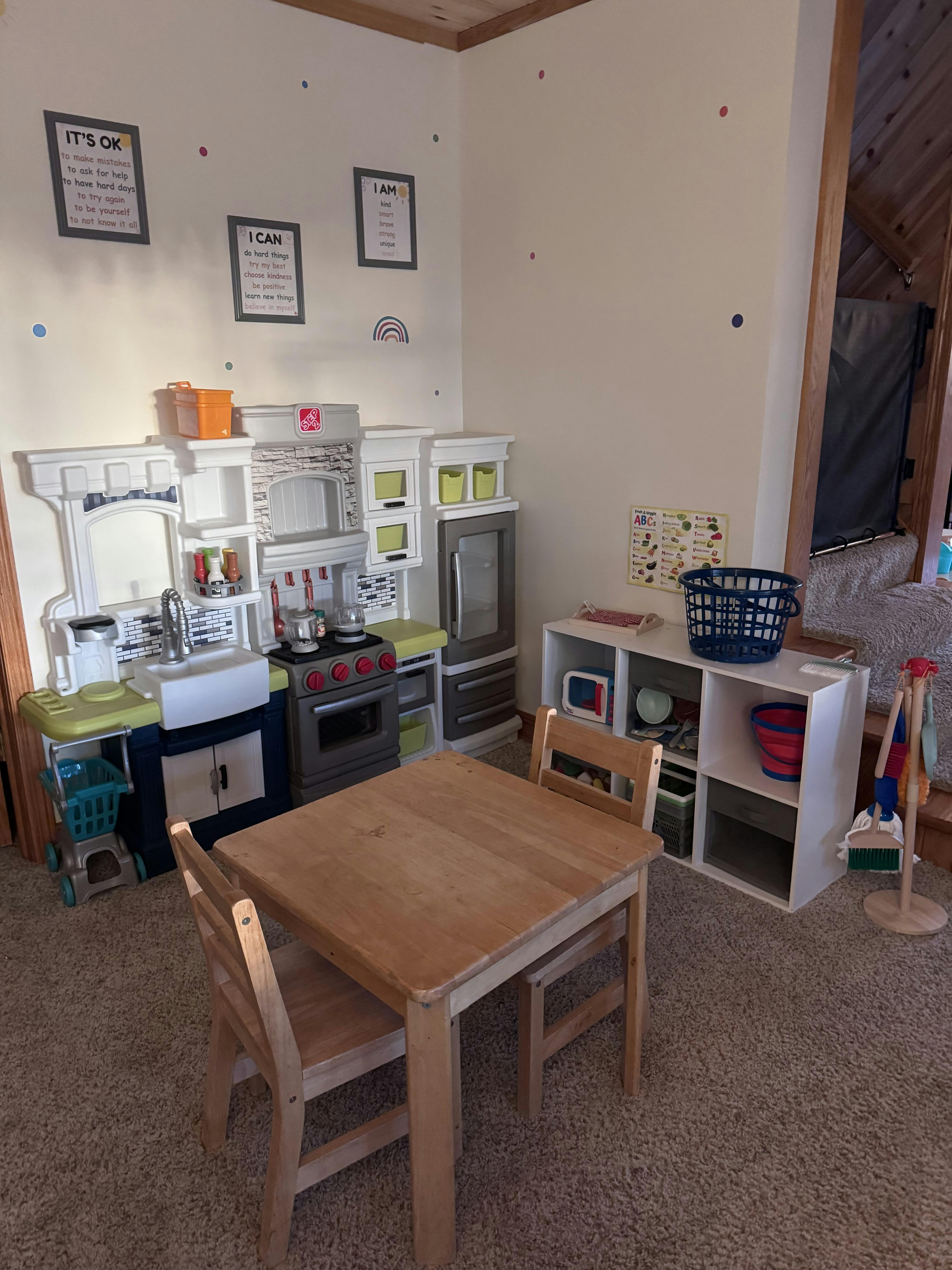 Childrens play kitchen set with wooden table and chairs in a play area