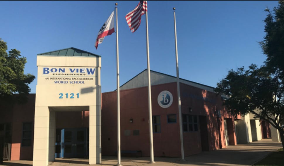 Building with "Bon View" and "2121" on its facade, with flags flying