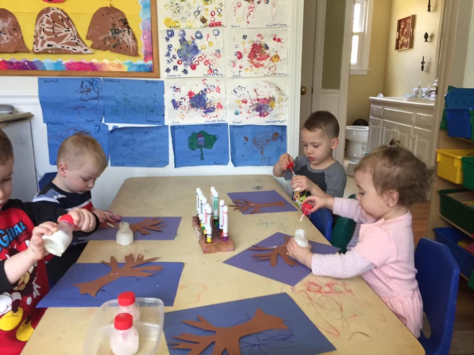 Children doing crafts at a table in a classroom