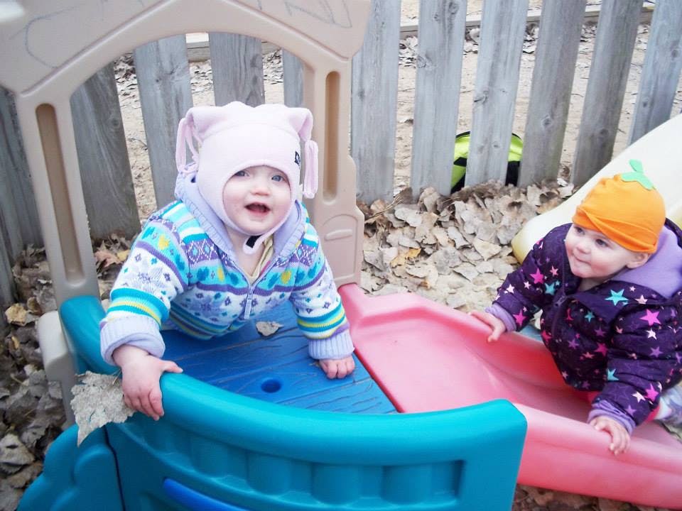 Two children playing on a small slide