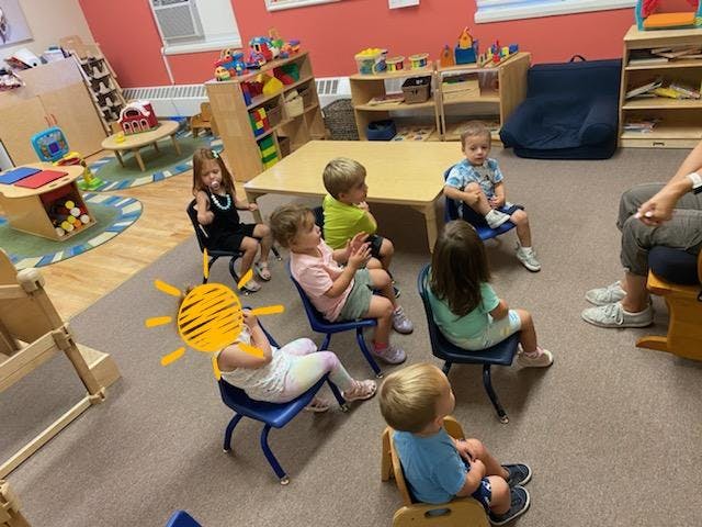 Children sitting in chairs in a classroom