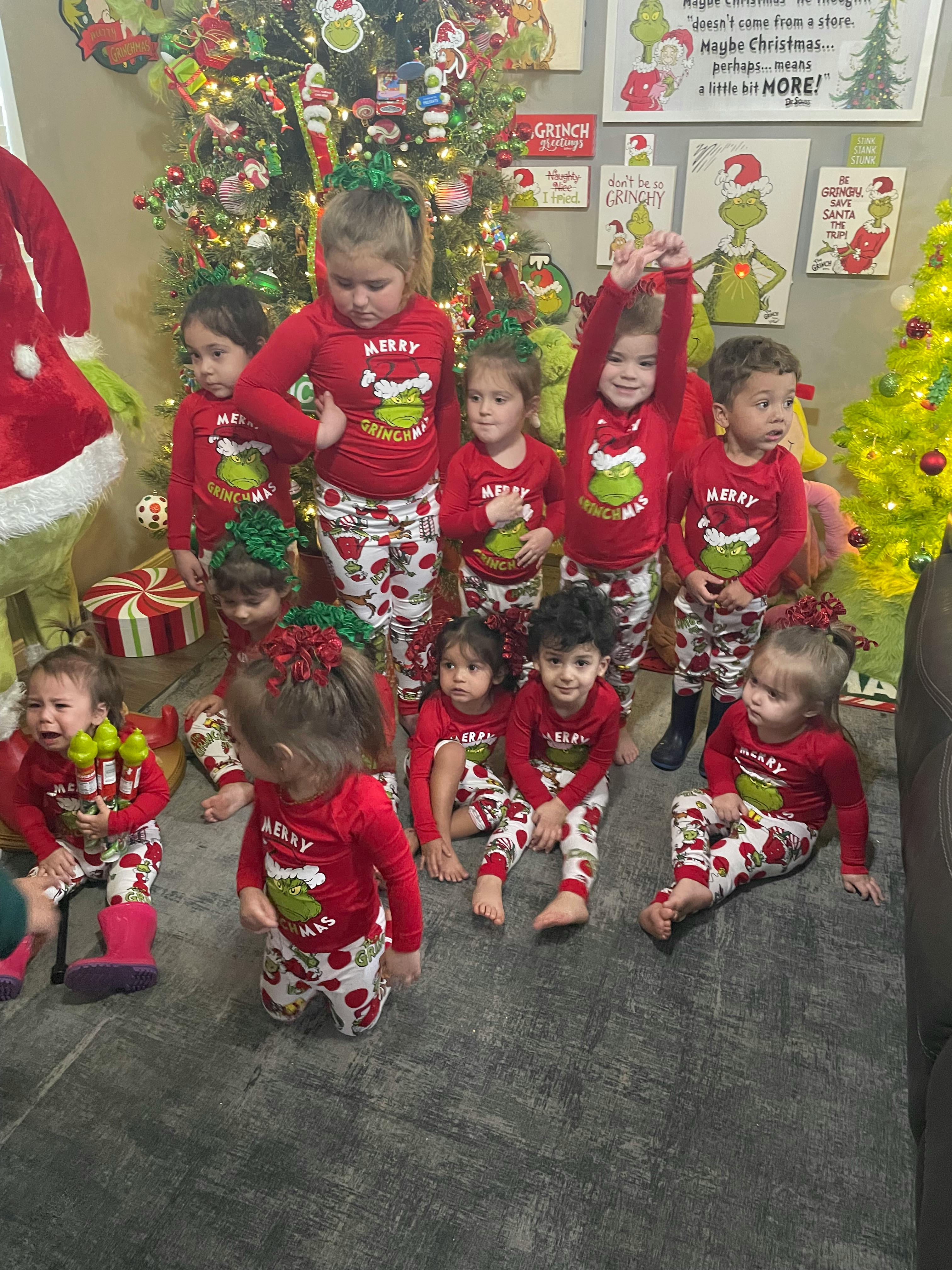Group of children in red and white pajamas with Christmas trees