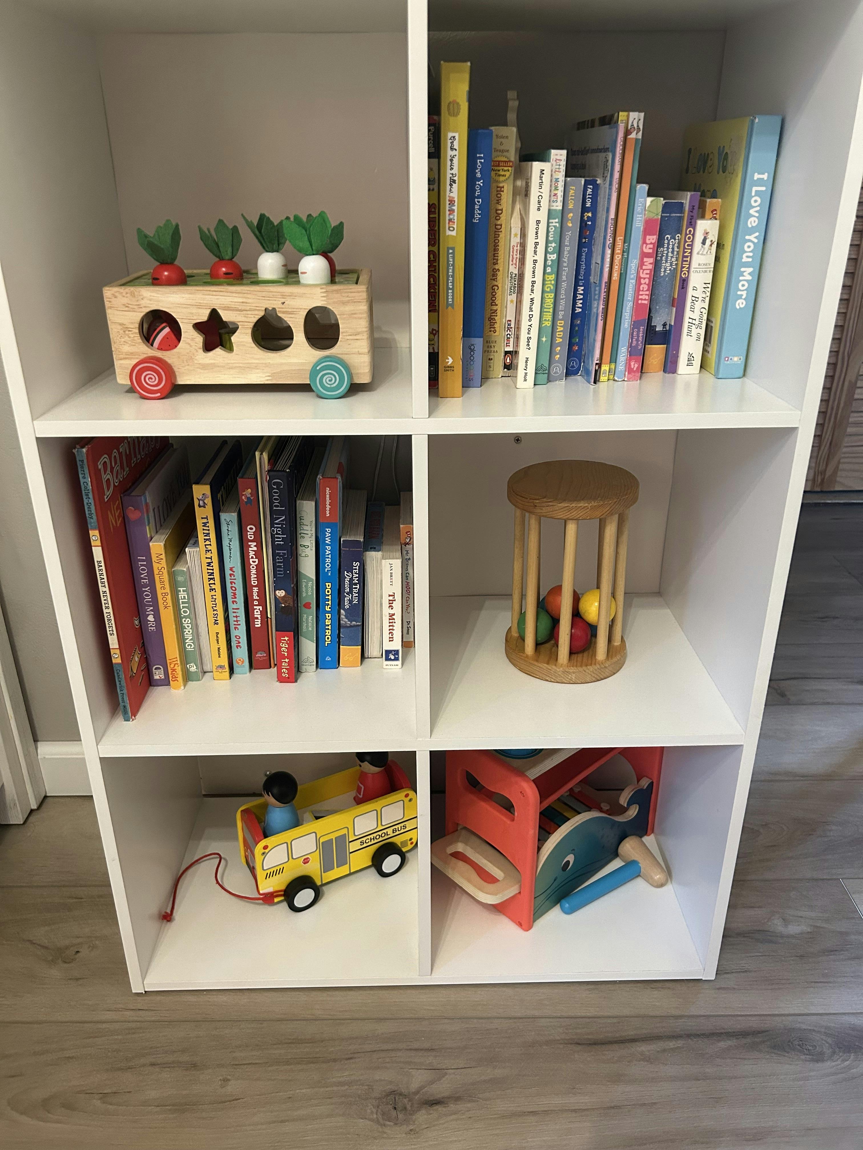White cubby shelf with books and children's toys