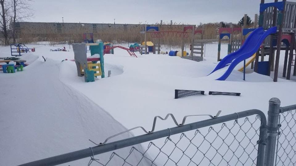 Snow-covered playground with slides and climbing structures