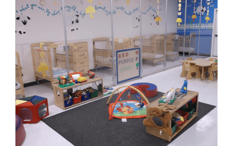 Cribs and play area inside a nursery classroom
