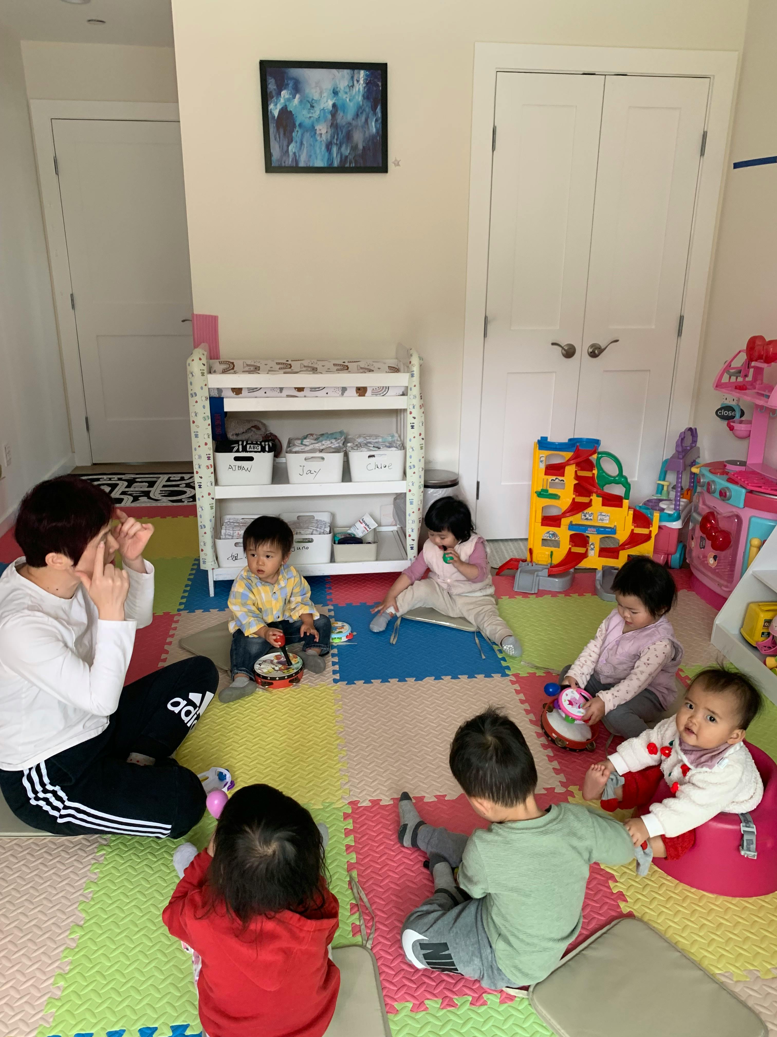 A group of children playing with toys on a mat in a room