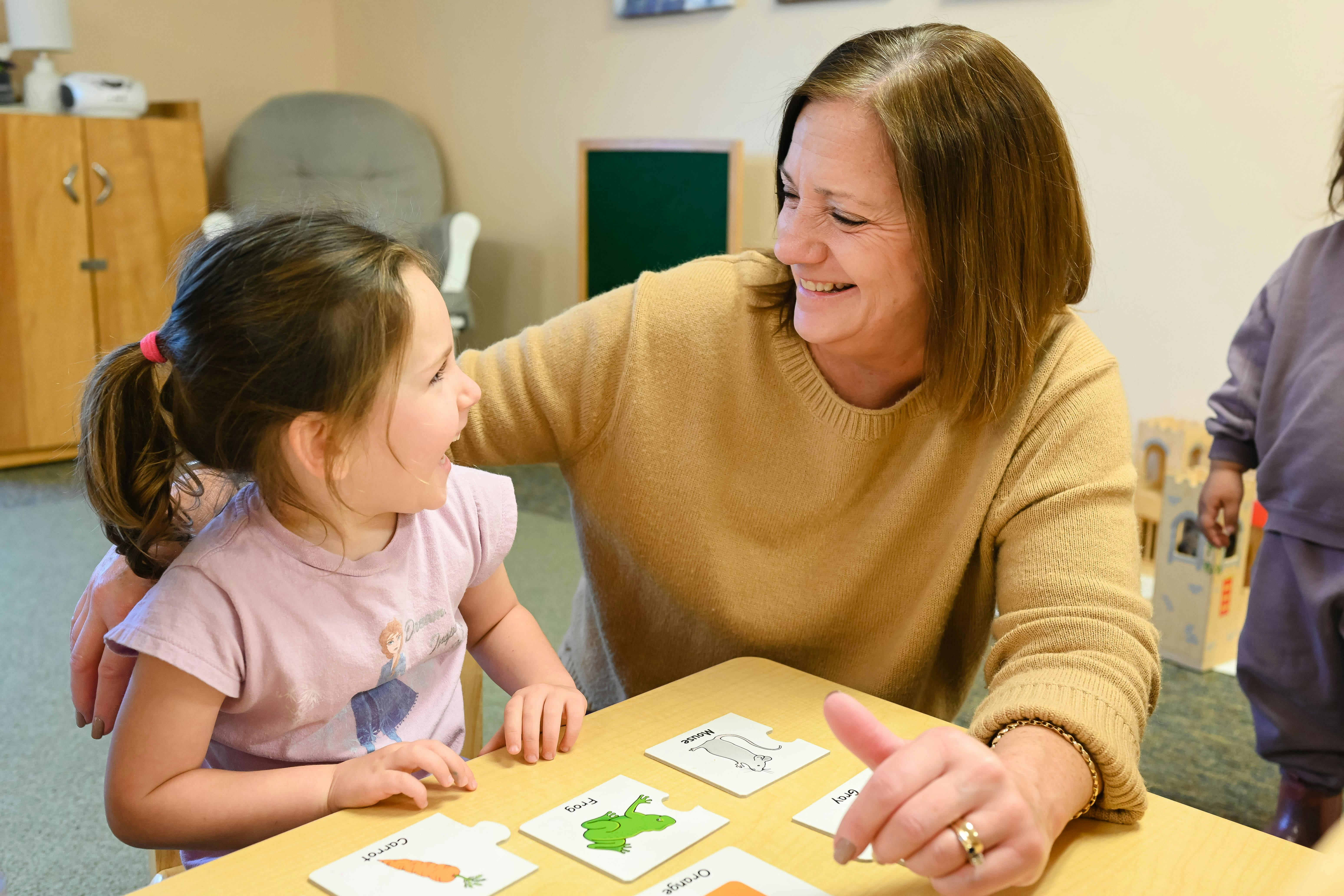Adult and child at a table with cards