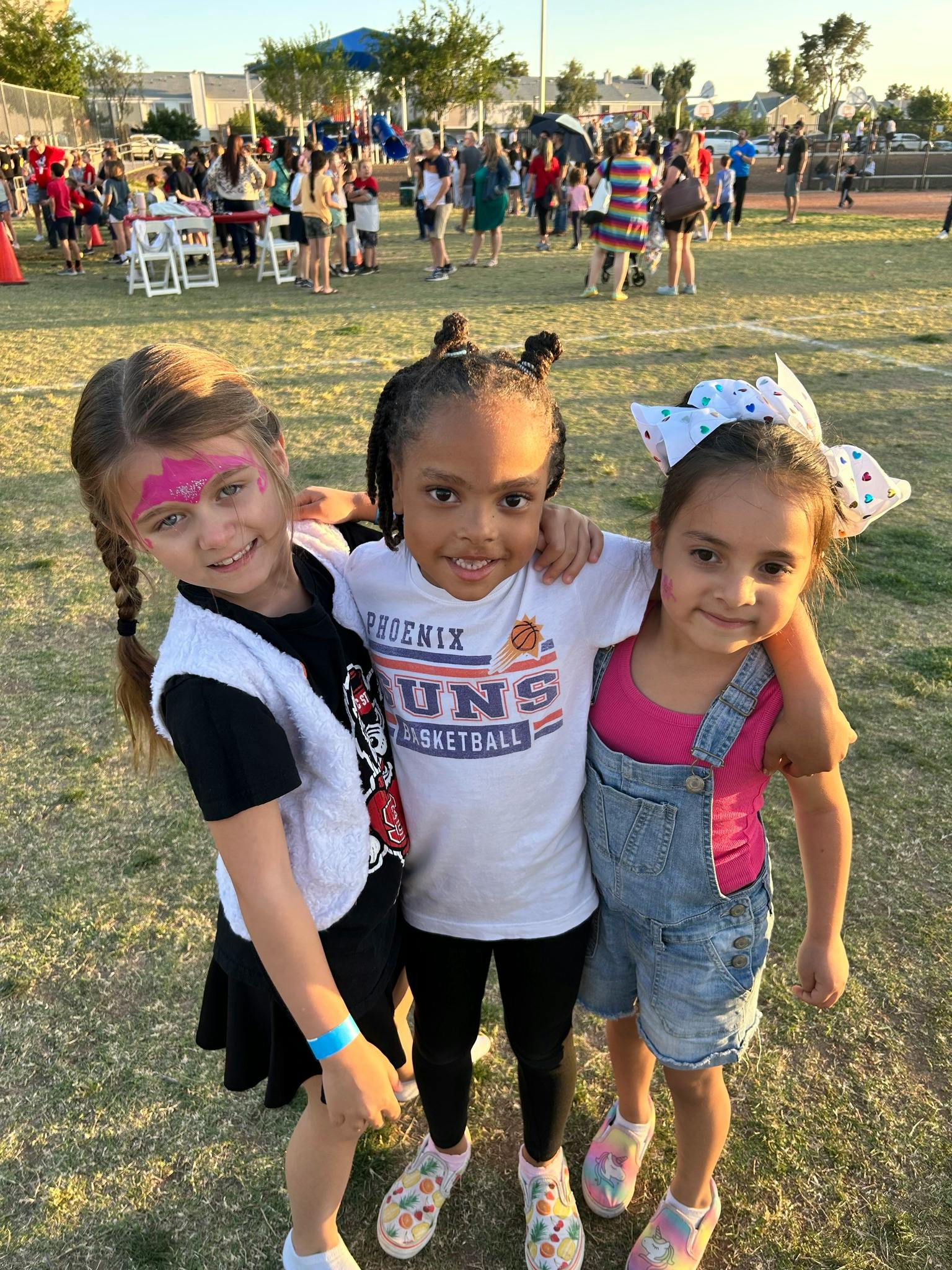 Three children standing together outdoors