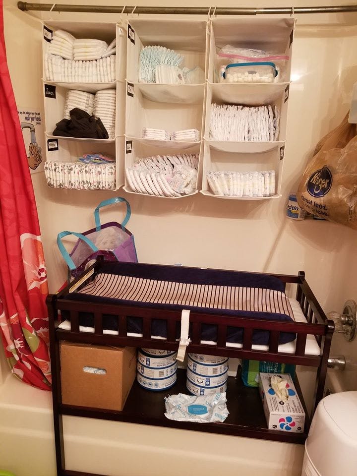 Changing table with hanging organizers filled with baby supplies
