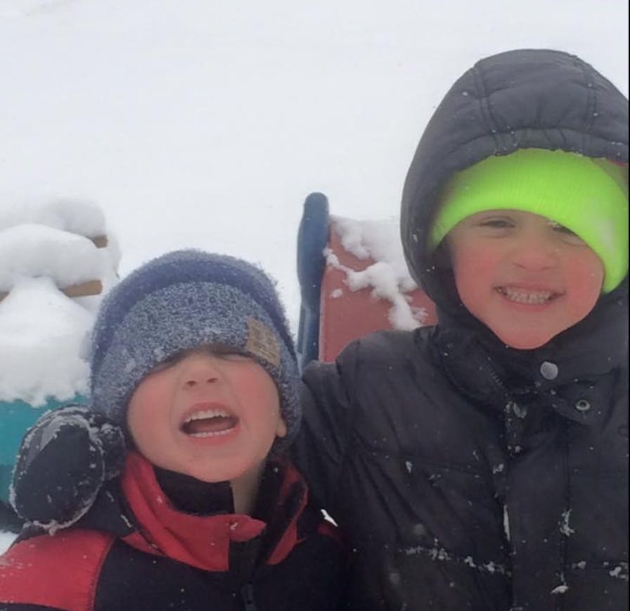 Two children in winter clothing in the snow