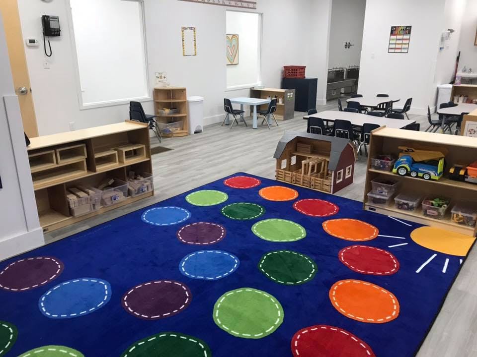 Classroom with a colorful polka dot rug and small tables and chairs