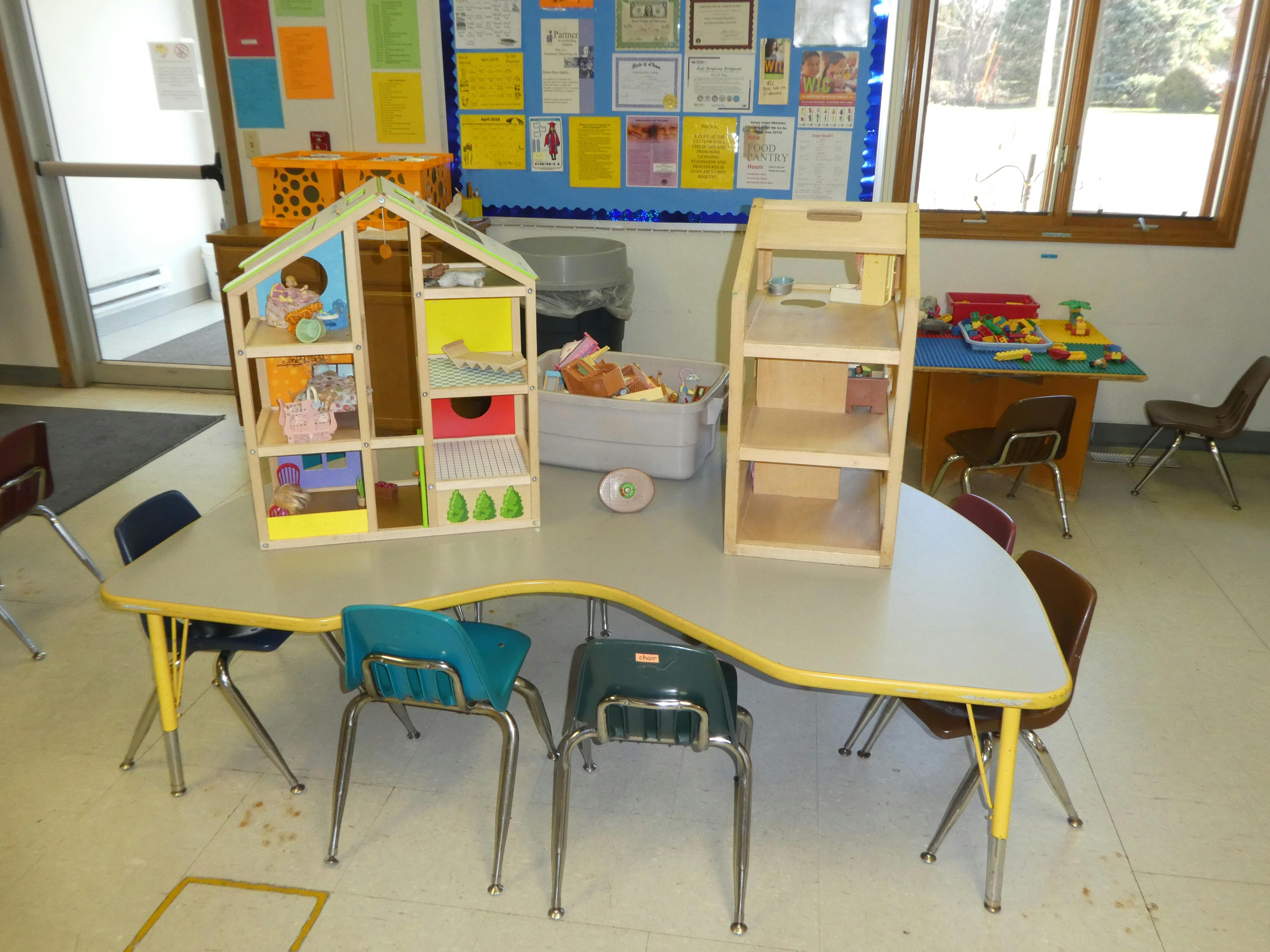 Dollhouse and wooden shelf on a classroom table
