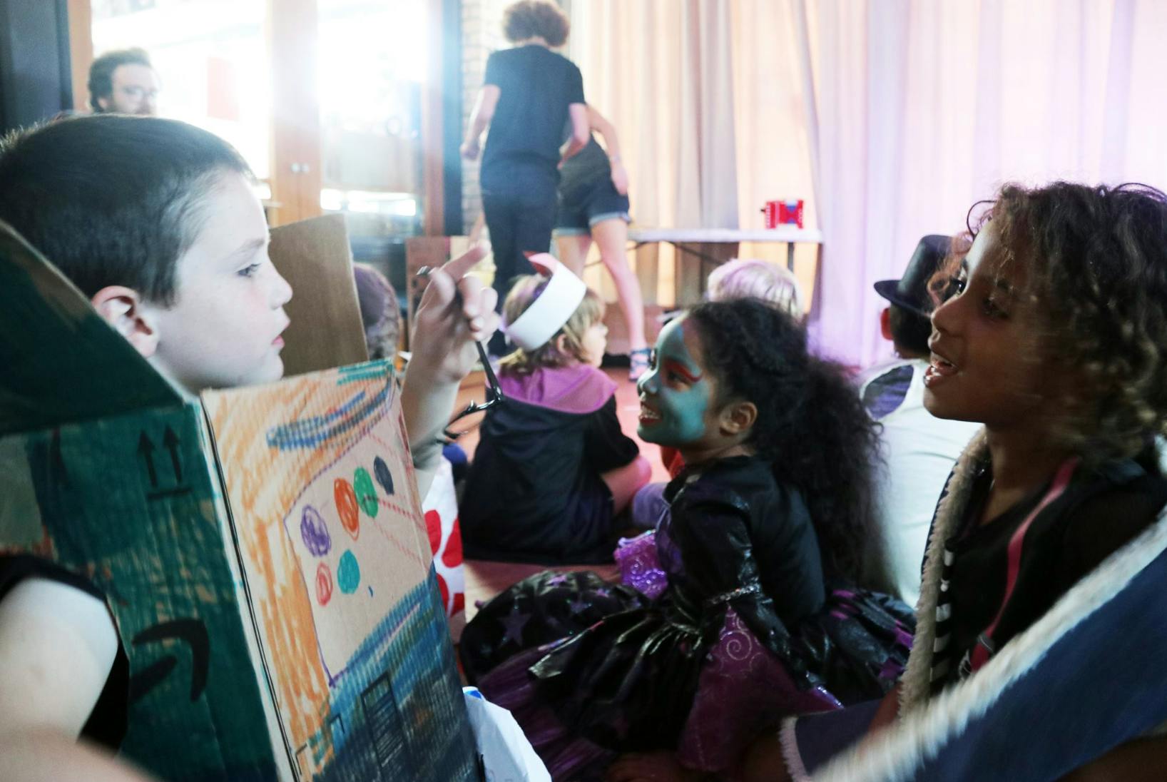 Child in costume painting a cardboard box
