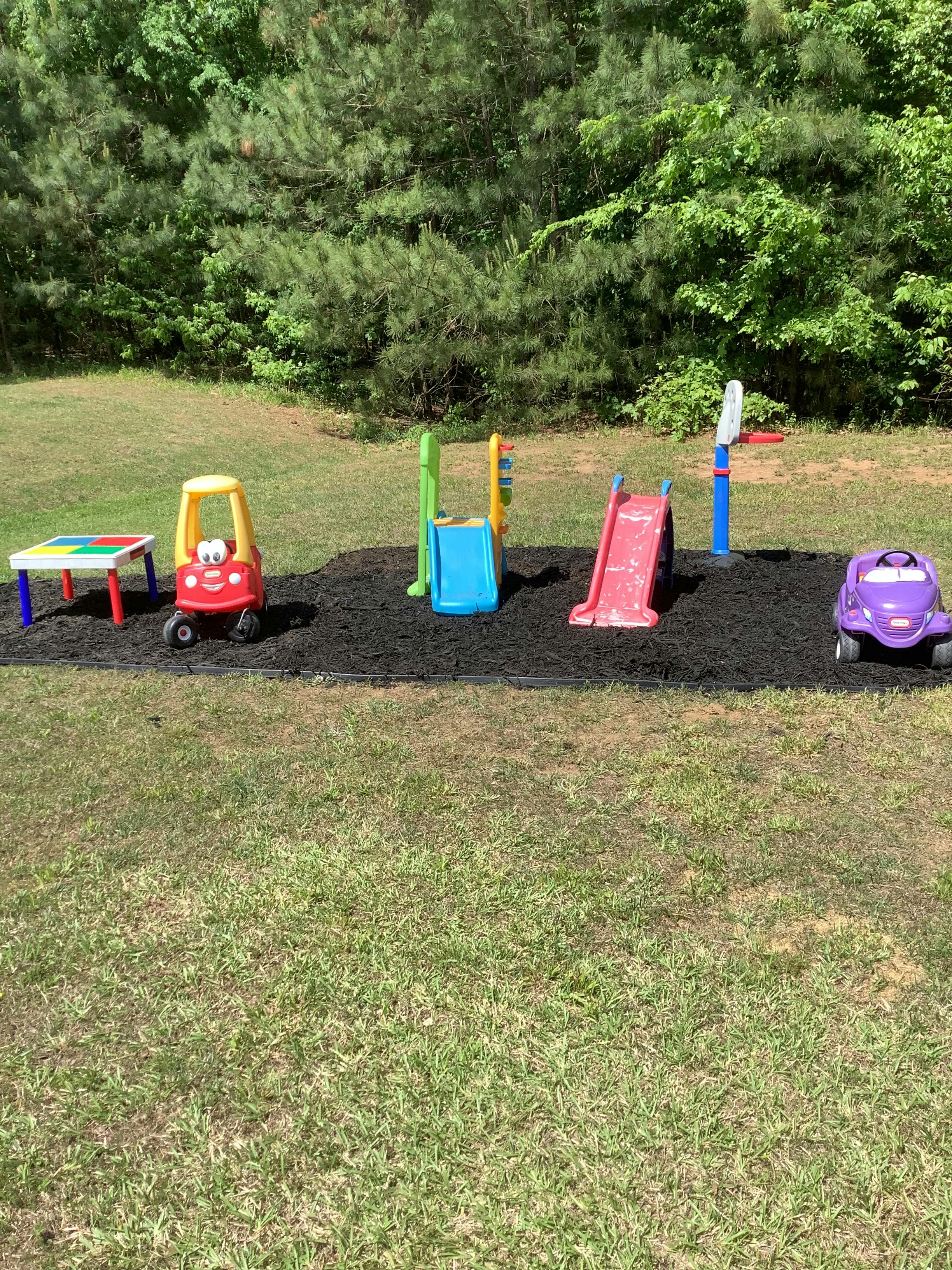 Outdoor playground with toy cars, slides, and a small table