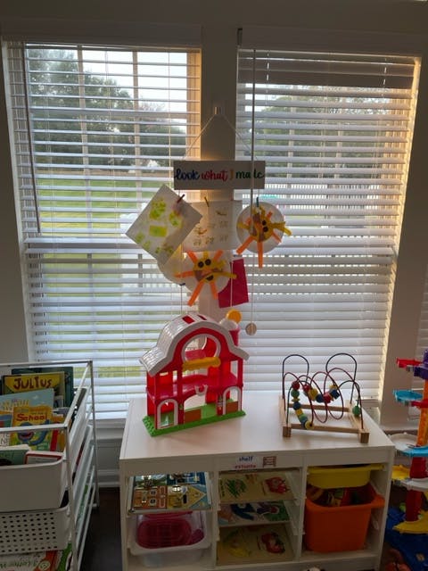 Children's toys and crafts on a table in front of a window