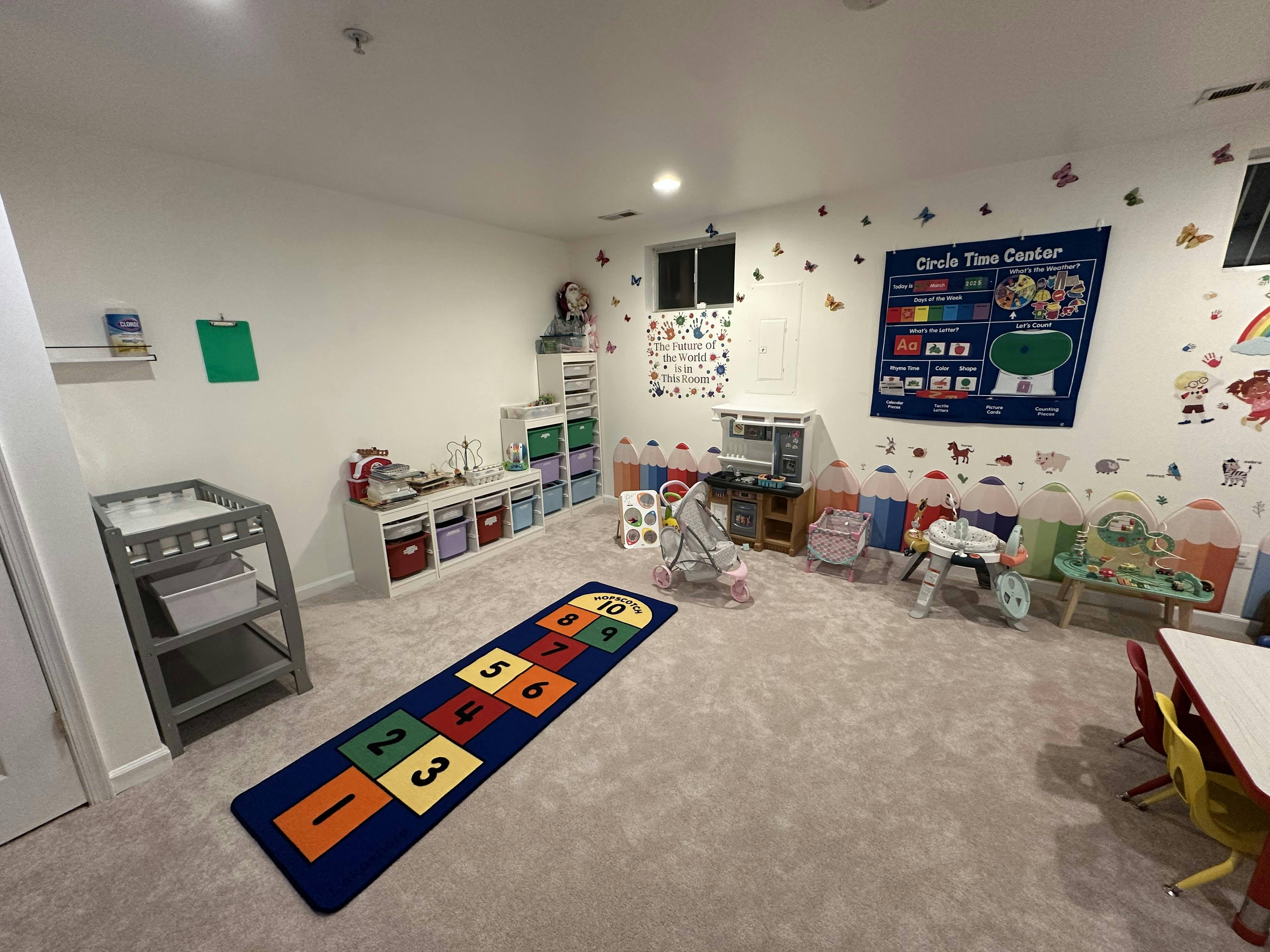 Playroom with a hopscotch rug, changing table, and toys