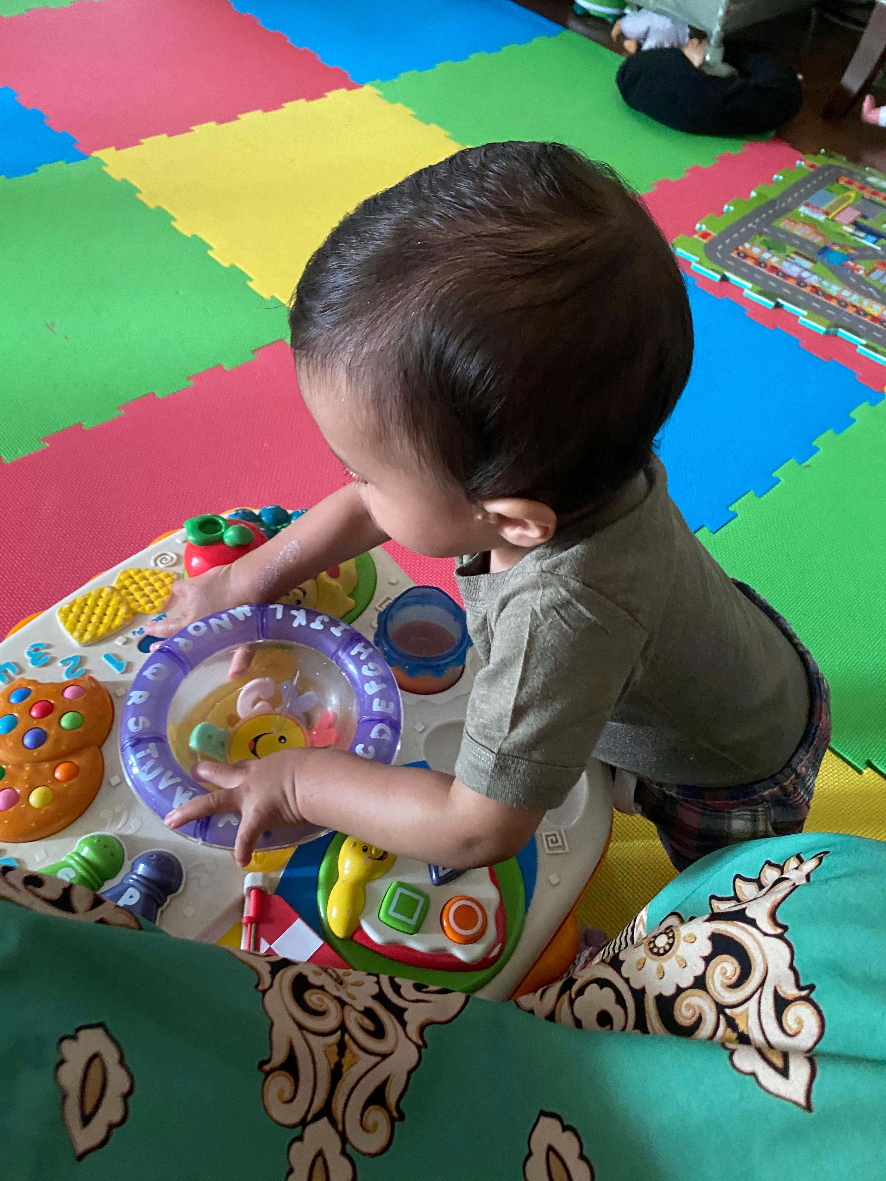 Child playing with a colorful activity table