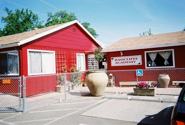 Red building with a sign that reads "Radcliffe Academy"