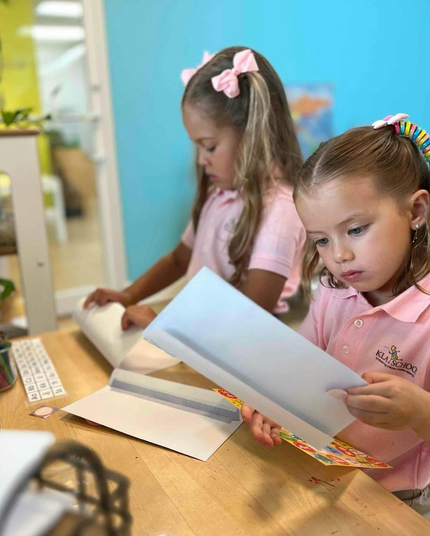Two children working with paper at a table