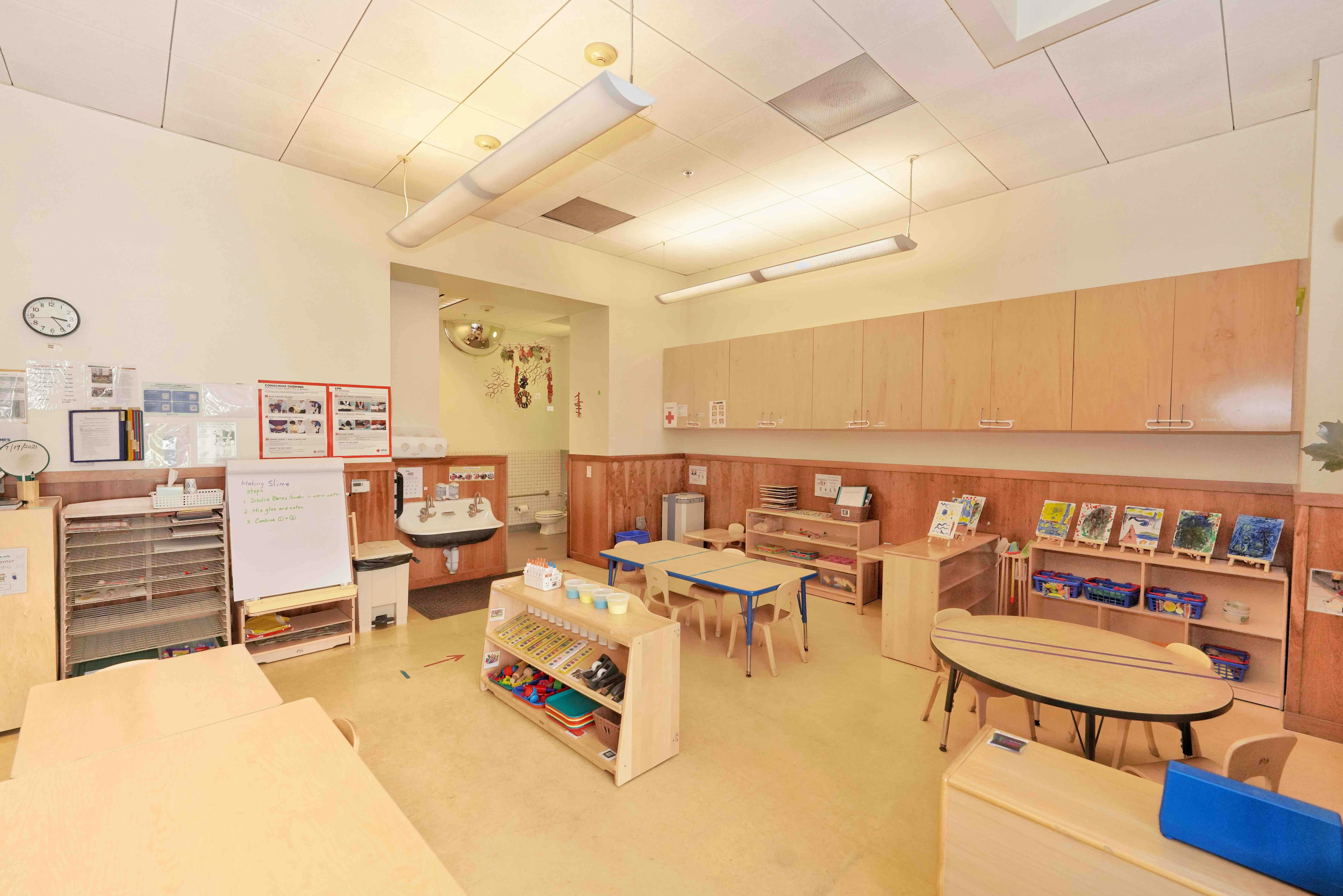 Classroom interior with child-sized furniture, shelving, and art displays