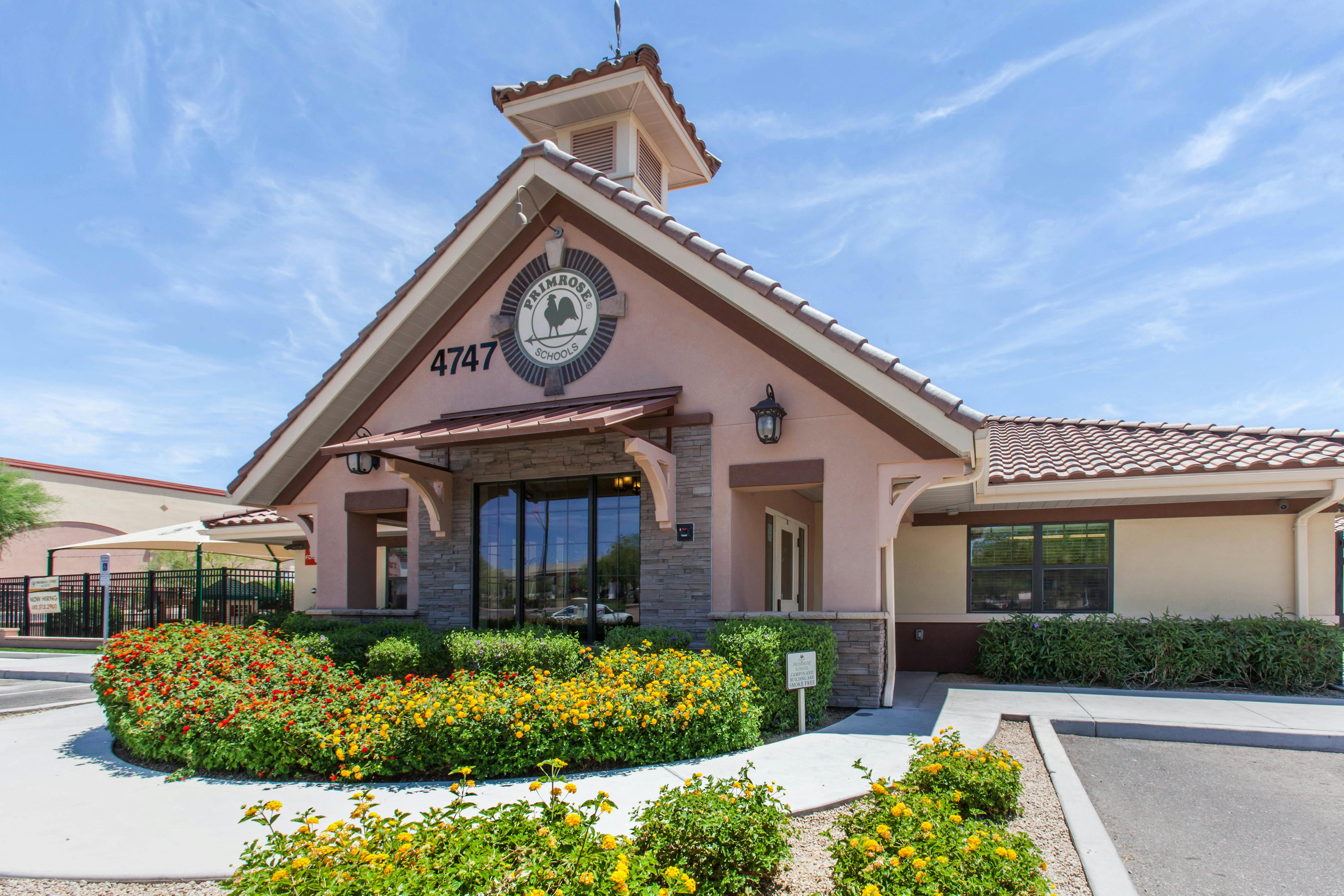 Front exterior of a Primrose Schools building with a flower bed and sign