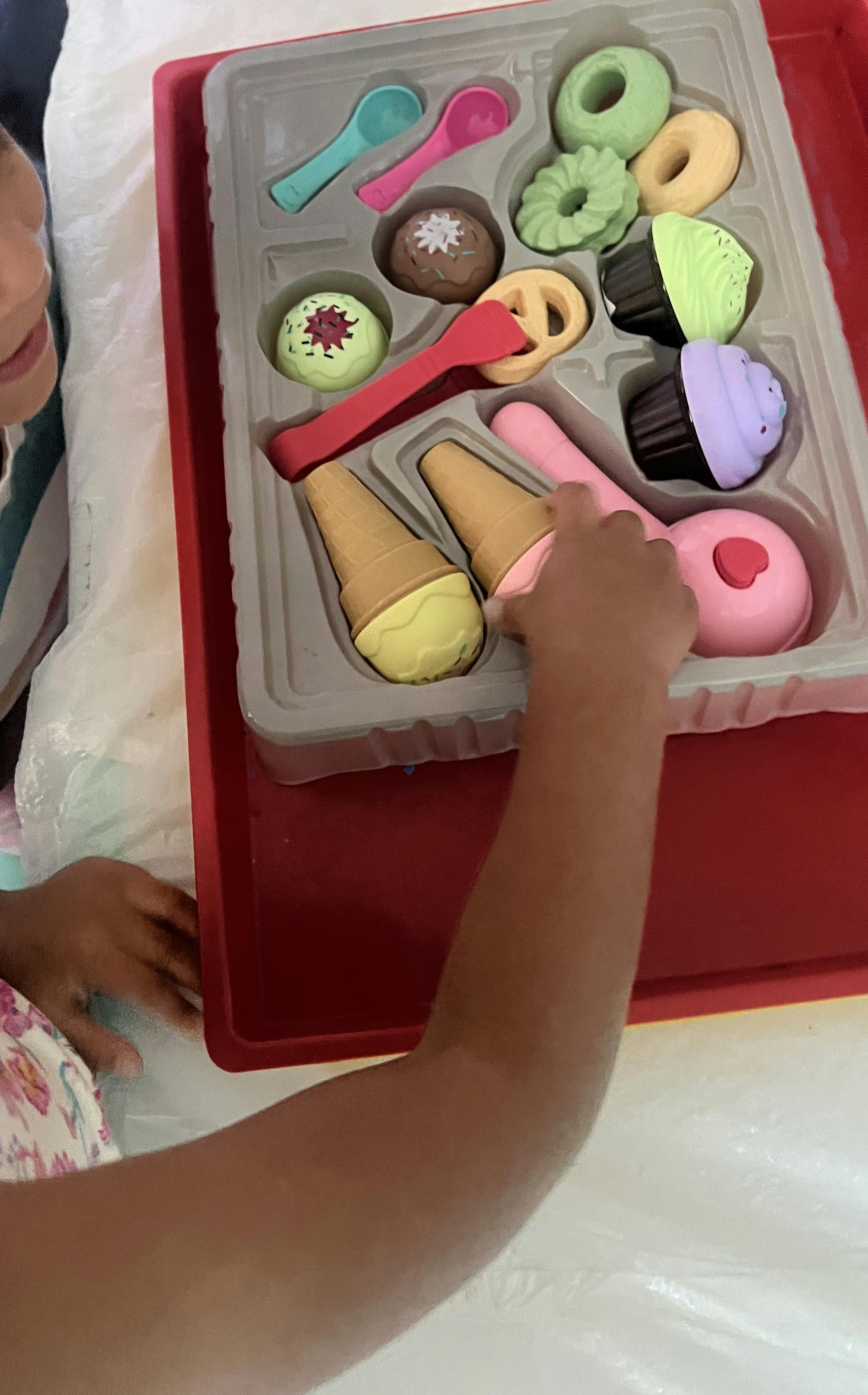 Child playing with a toy ice cream and dessert set