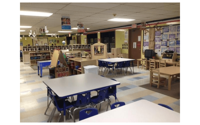 An empty classroom with various tables and chairs