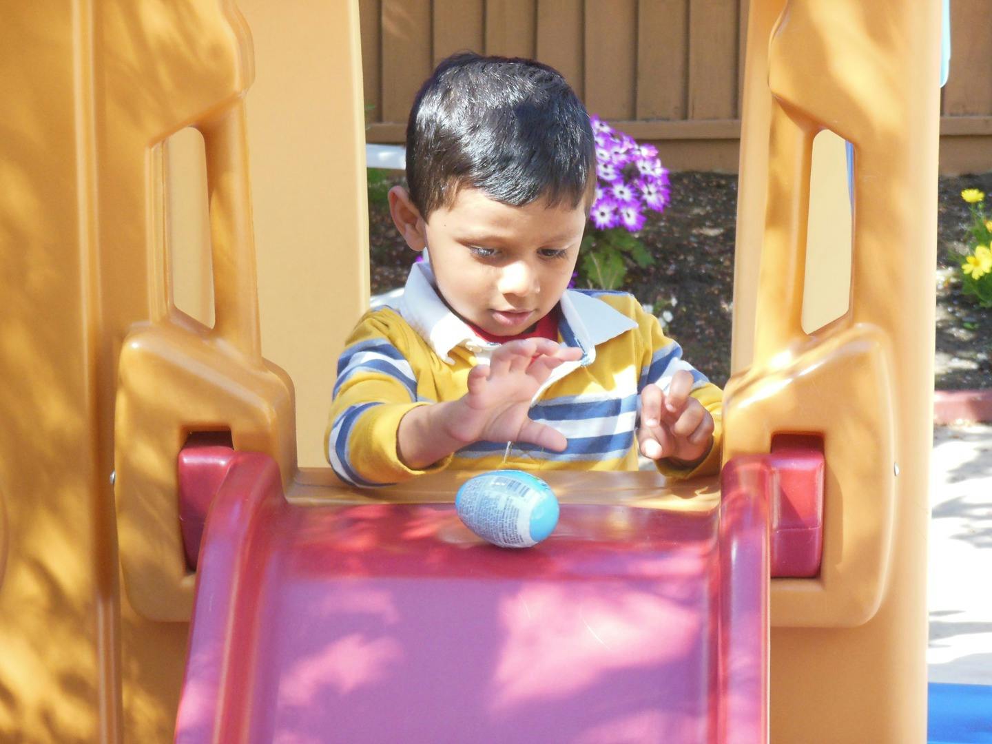 Child playing with a toy on a slide