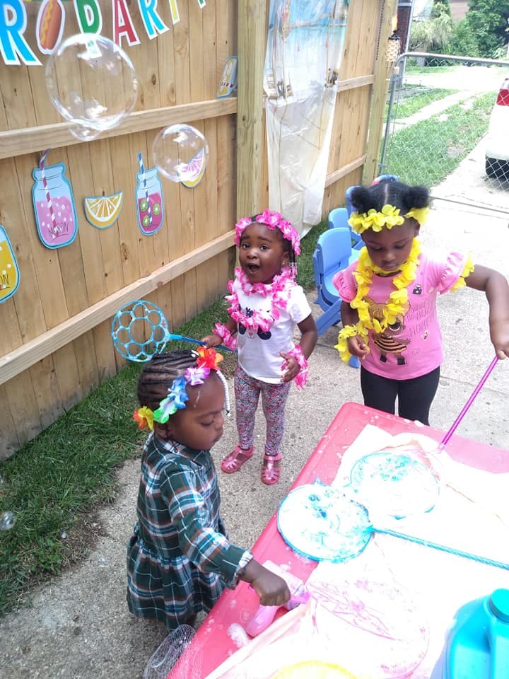 Three children playing with bubbles outdoors