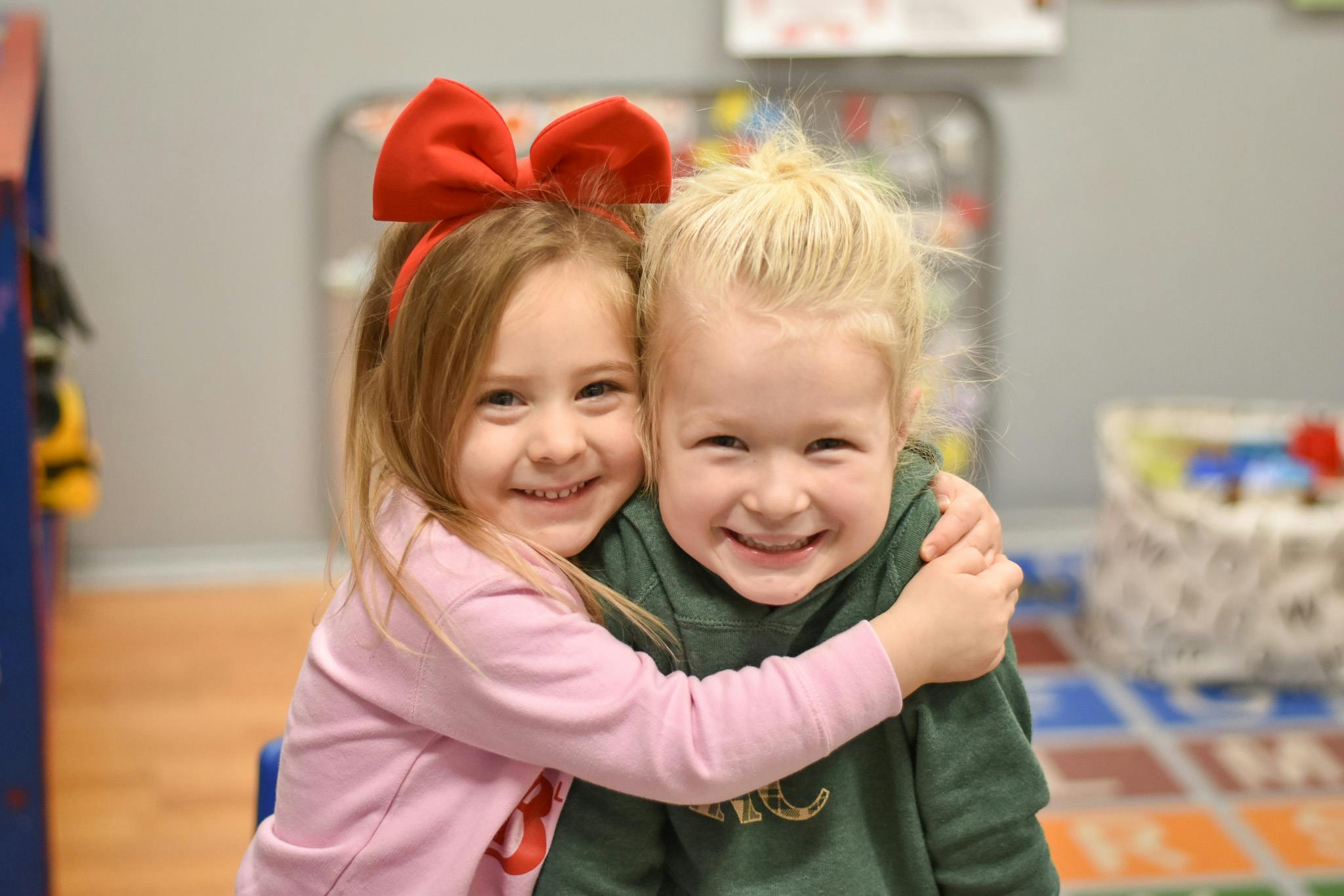 Two children embracing, smiling at the camera