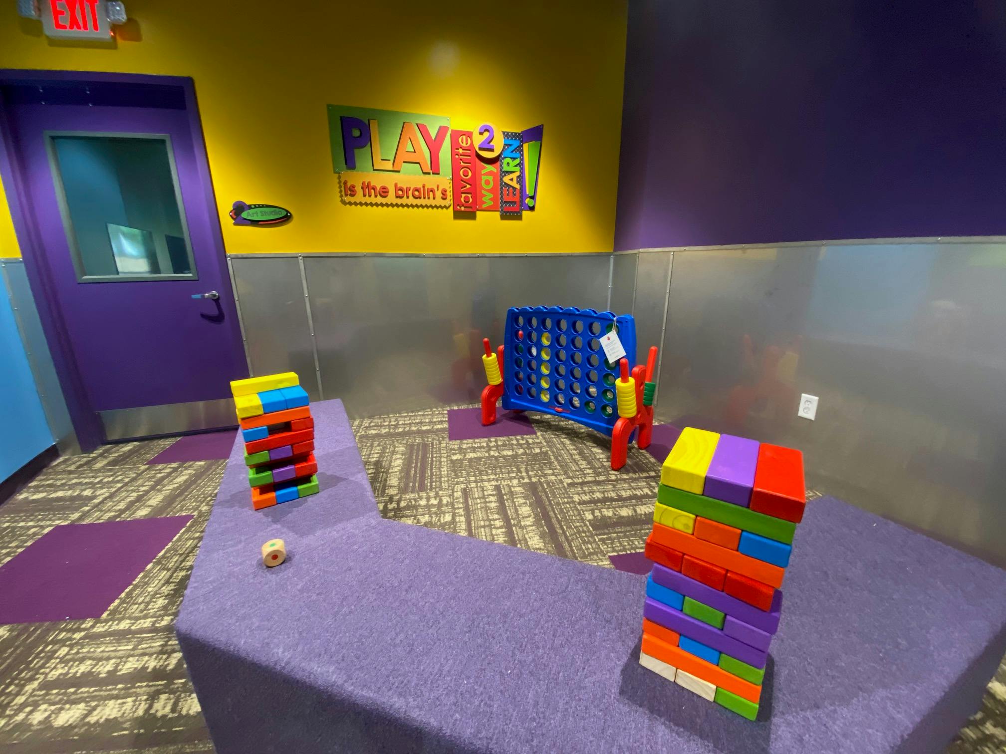 Colorful playroom with a large Connect Four game and Jenga blocks