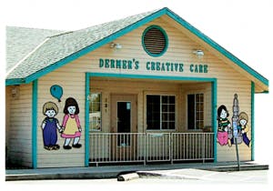 Building with "Dermen's Creative Care" sign and child cutouts