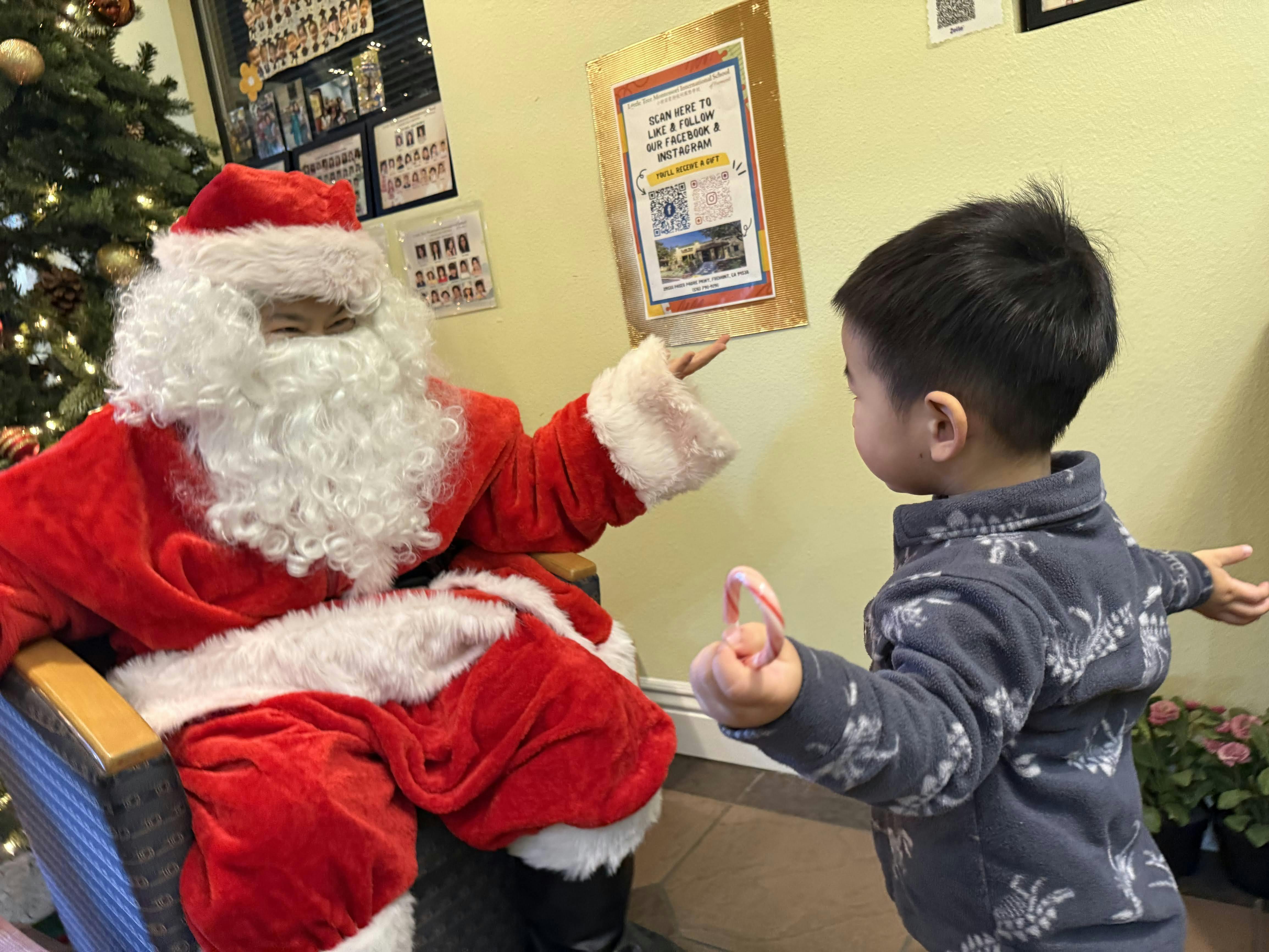 Person in a Santa costume interacting with a child holding a candy cane