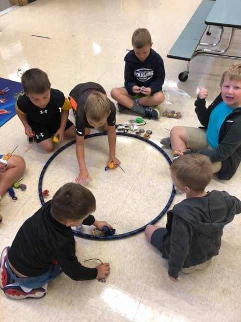 Children playing with toys on the floor around a hoop